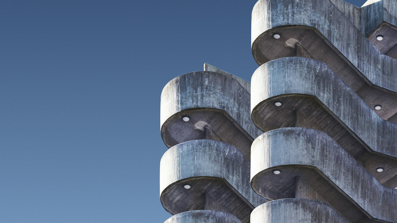 Curved concrete balconies on a building against a blue sky